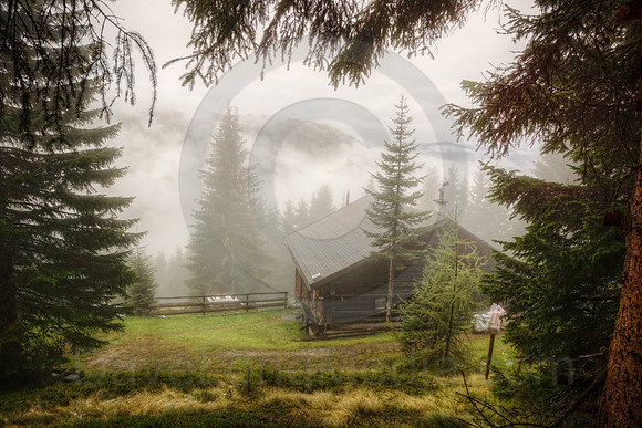 Cabin in the Alps on Misty Morning