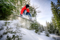 Snowboarder Jumping in Forest