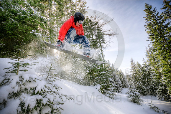 Snowboarder Jumping in Forest